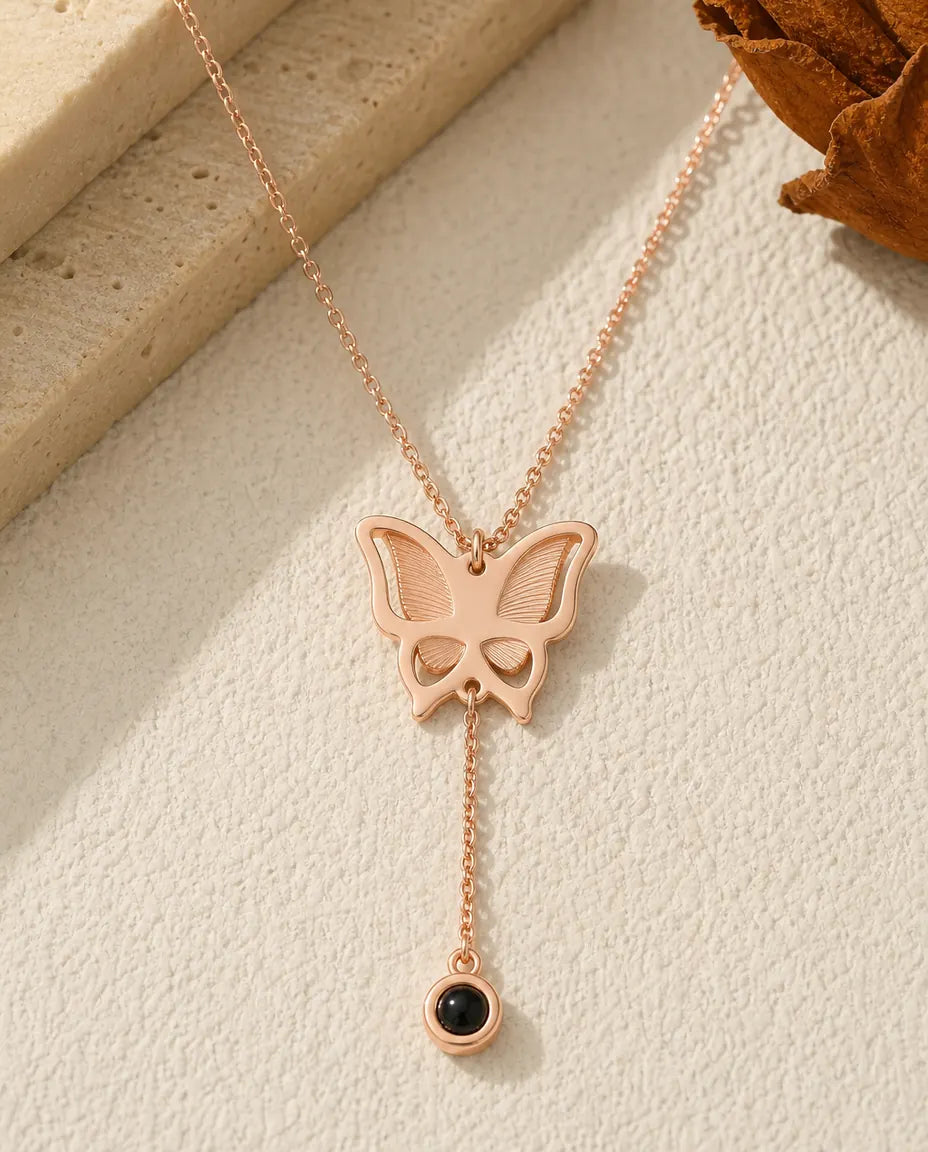 Rose gold butterfly photo projection necklace with a Y drop and black bead