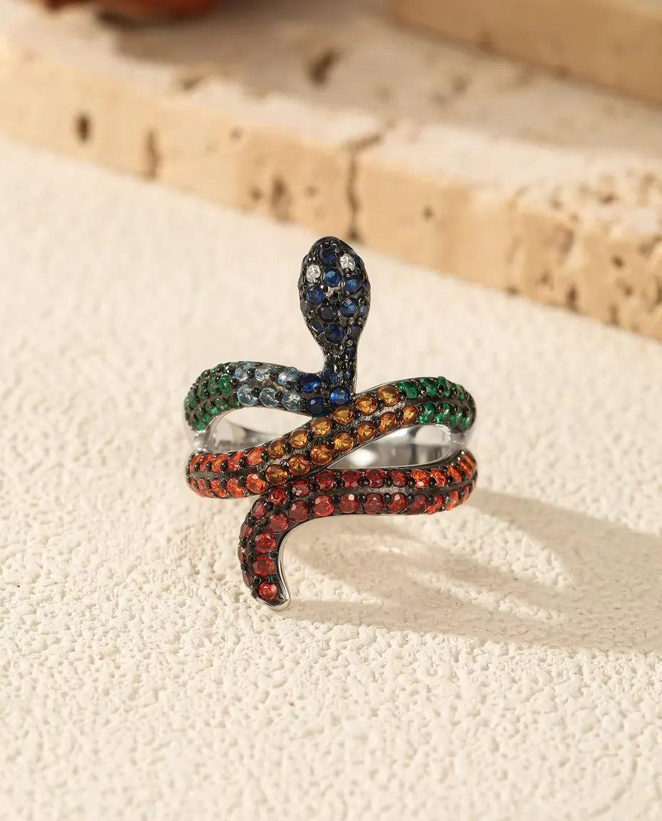 Snake Ring in 925 Sterling Silver with Rainbow Colored Stones - standing upright on a cream textured surface