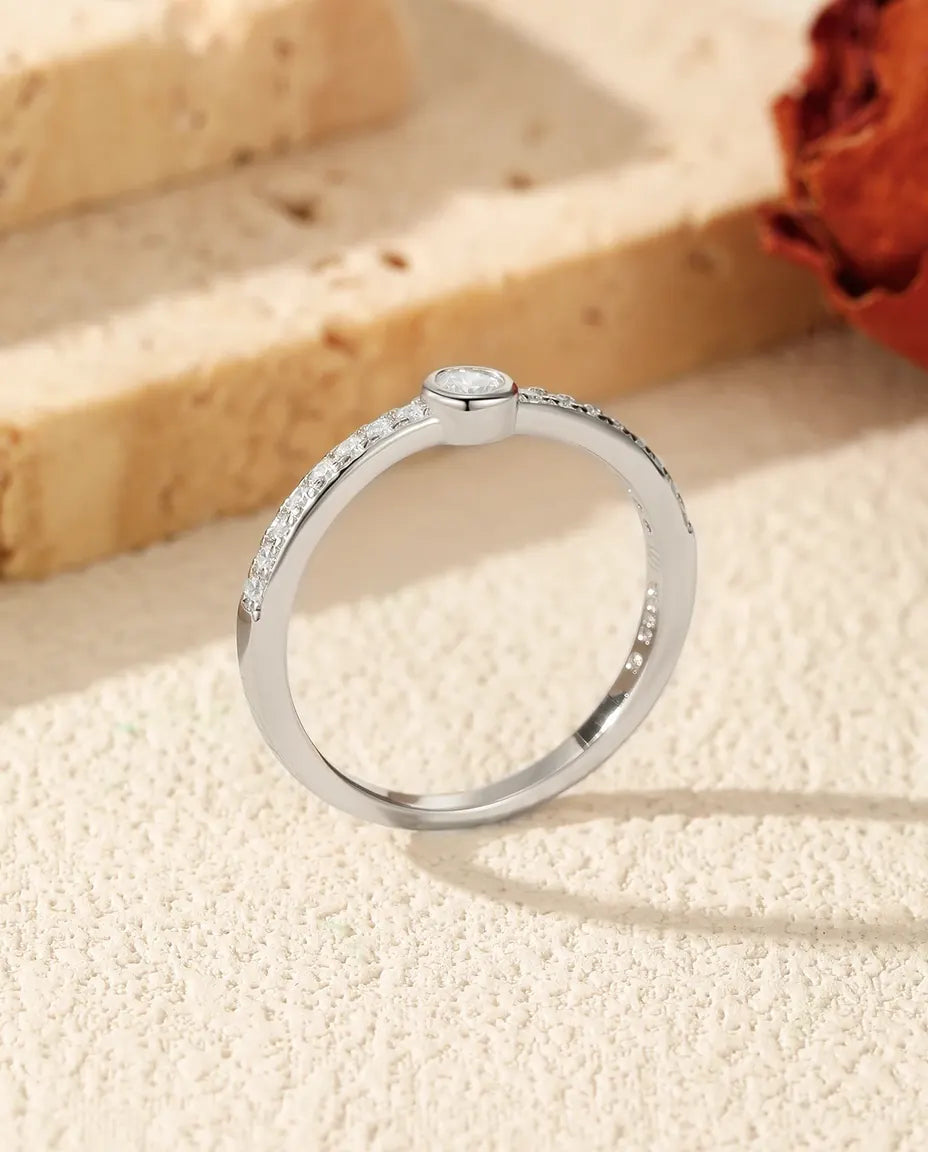 Bezel-set moissanite solitaire ring in 925 sterling silver with pave shoulders