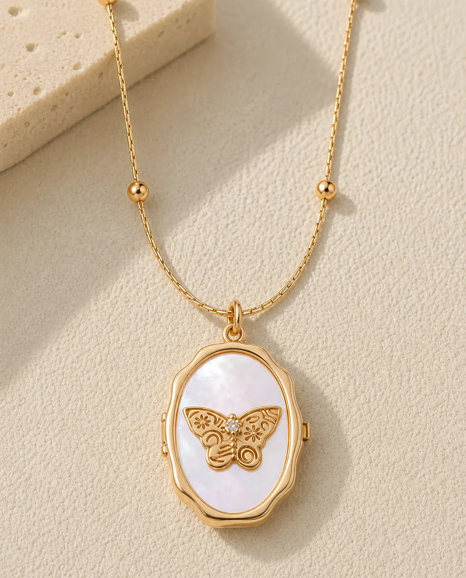 Personalized butterfly mother of pearl photo locket necklace in gold, closed, flat lay