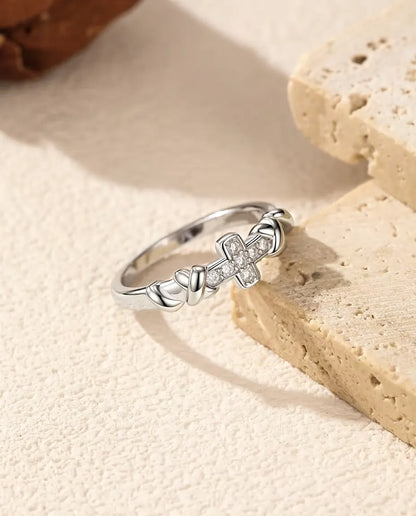 Cross Moissanite Ring in 925 Sterling Silver - resting on the edge of a travertine slab
