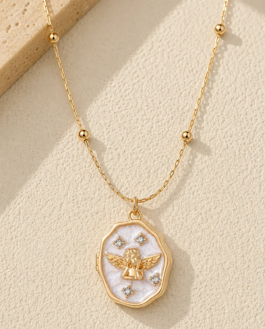 Personalized guardian angel mother of pearl photo locket necklace in gold, closed, flat lay