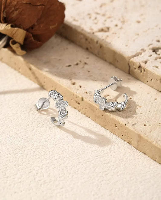 Moissanite Cross Hoop Earrings in 925 Sterling Silver - pair standing side by side on a cream textured surface