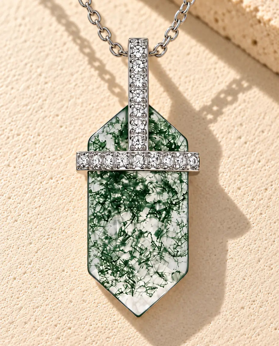Moss Agate Hexagon Bar Necklace in 925 Sterling Silver - lying on a cream textured surface beside a travertine block