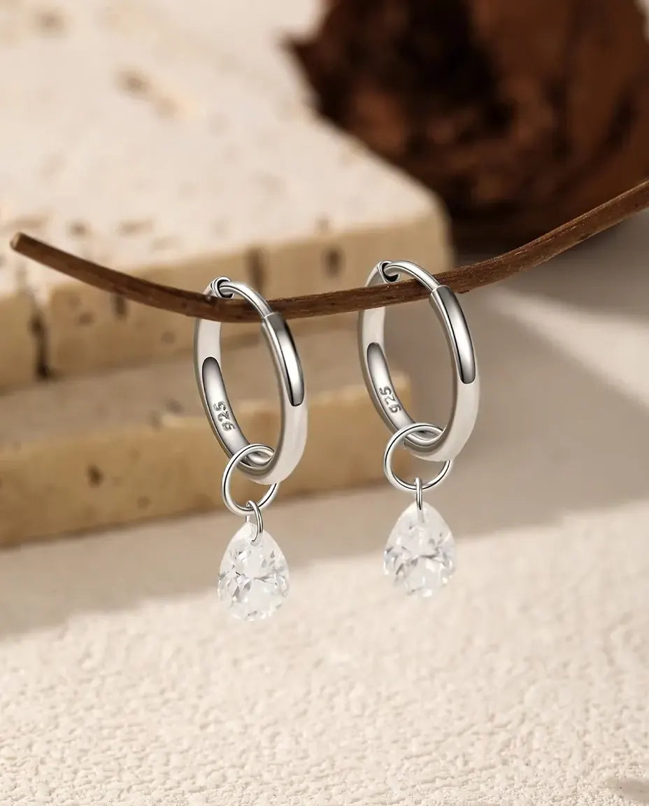 Moissanite Drop Hoop Earrings in 925 Sterling Silver - pair hanging from a slim branch