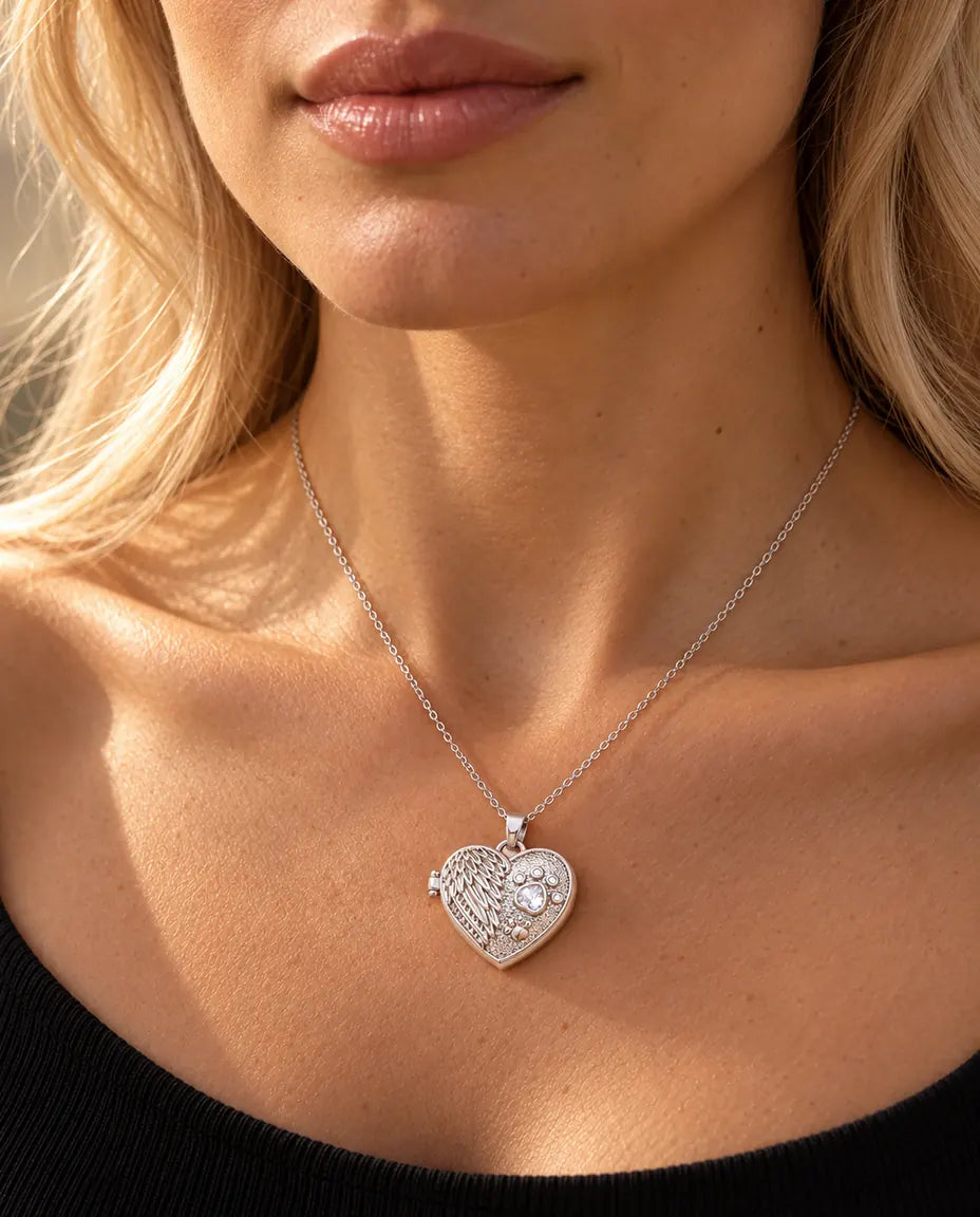 Woman in a black knit top wearing the silver tone angel wing paw print heart photo locket necklace