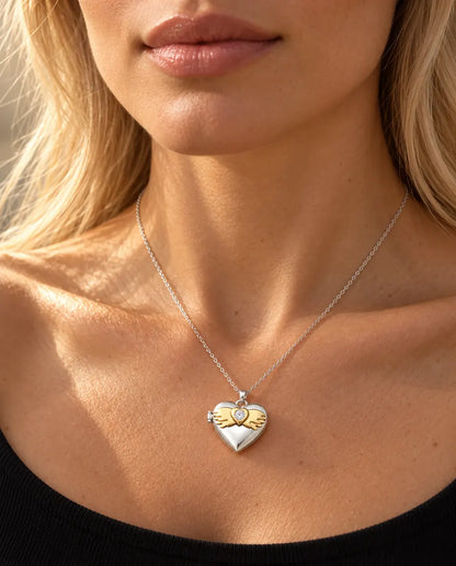 Woman in a black knit top wearing the silver tone angel wings heart photo locket necklace
