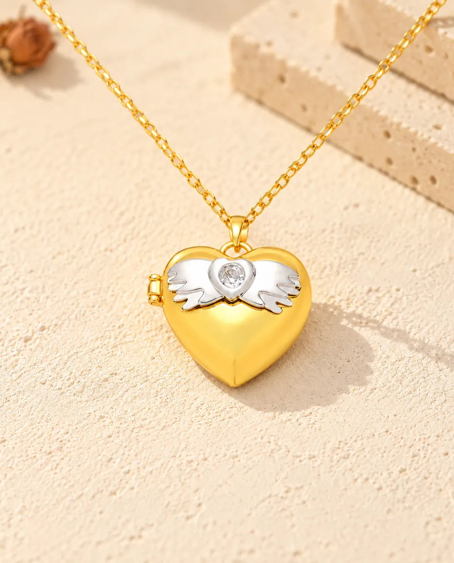 Front view of the gold tone angel wings heart photo locket showing the lid design and side hinge
