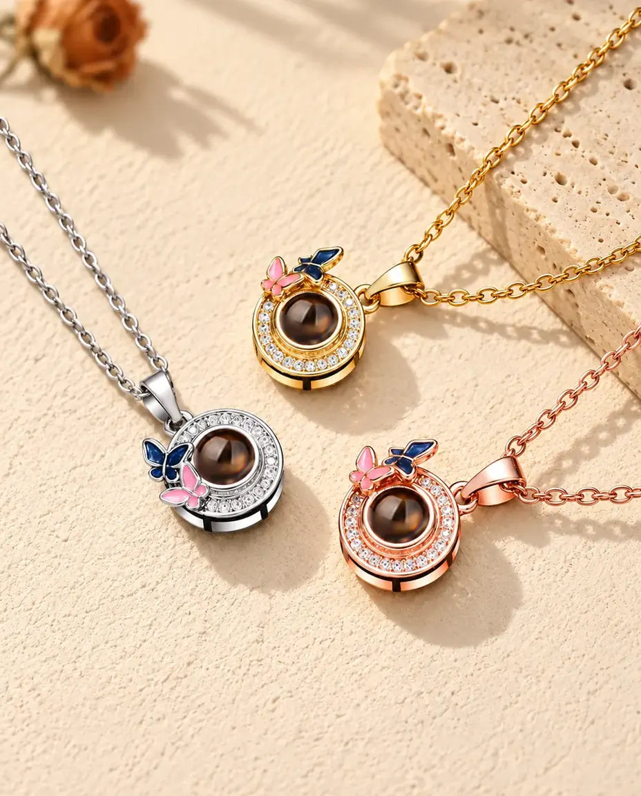 Gold tone, silver tone and rose gold tone butterfly circle necklaces beside a travertine slab