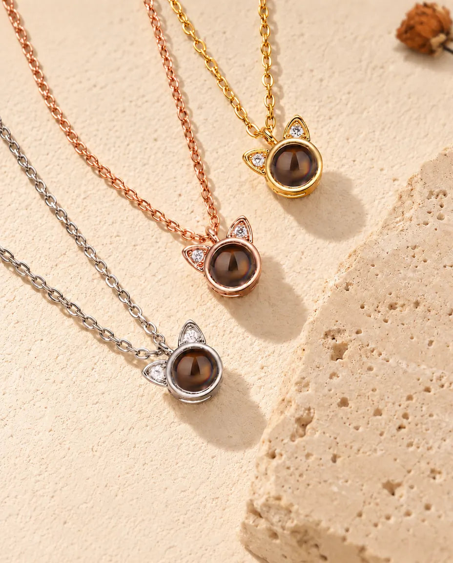Gold tone, rose gold tone and silver tone cat ear pendants laid diagonally