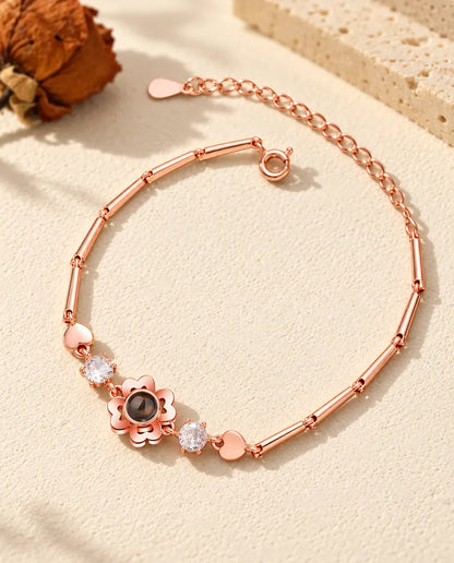 Rose gold tone clover flower bracelet with cubic zirconia and small heart links