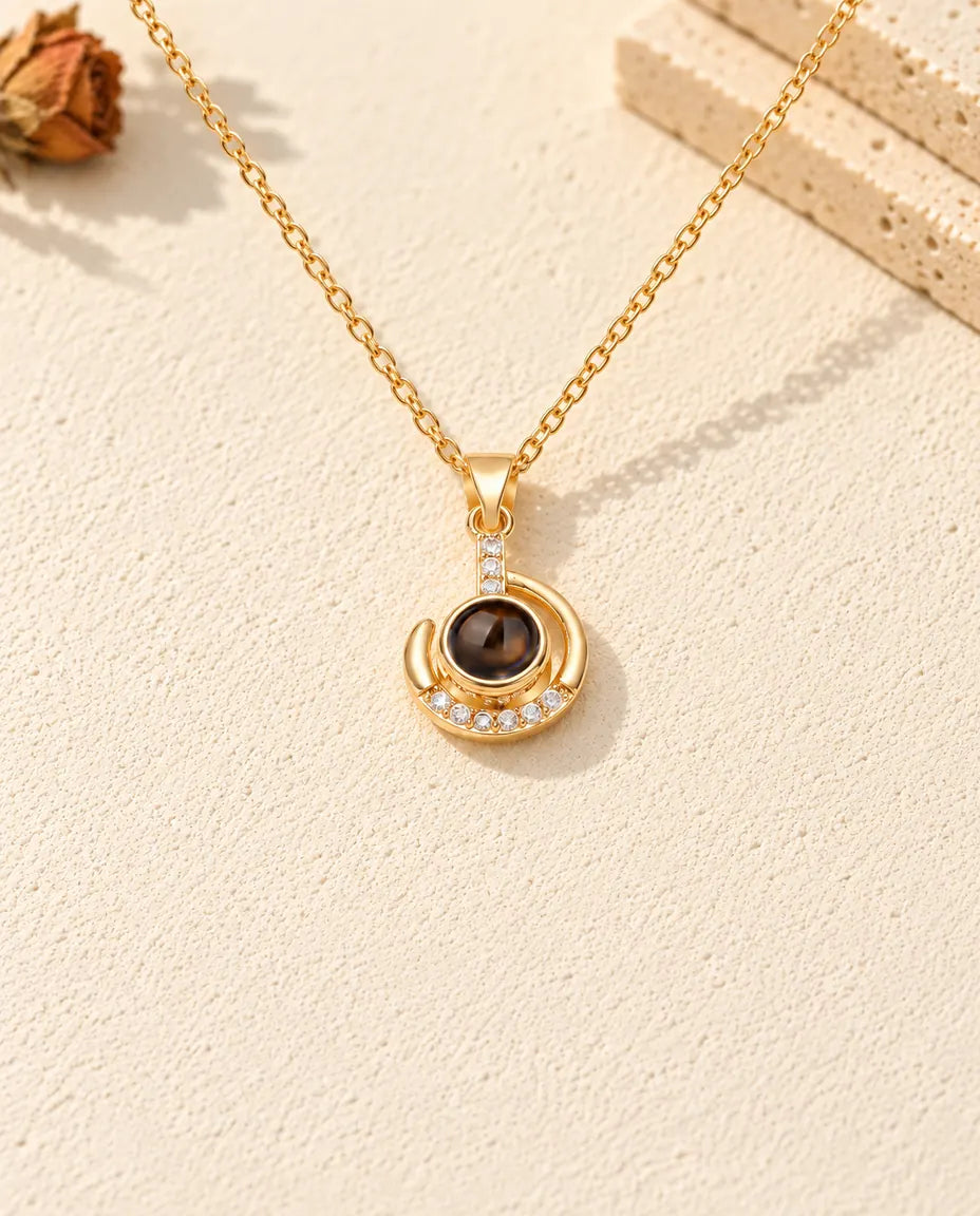 Front view of the gold tone crescent curling around the projection stone