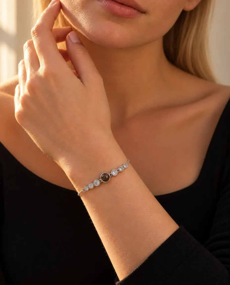 Woman touching her jawline, wearing the silver tone stone row photo projection bracelet