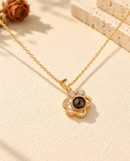 Front view of the gold tone paw print pendant with four cubic zirconia toes
