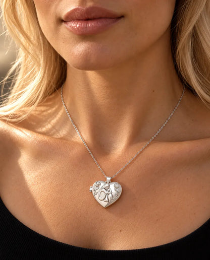 Woman in a black knit top wearing the silver tone heart photo locket with a woman and her dog