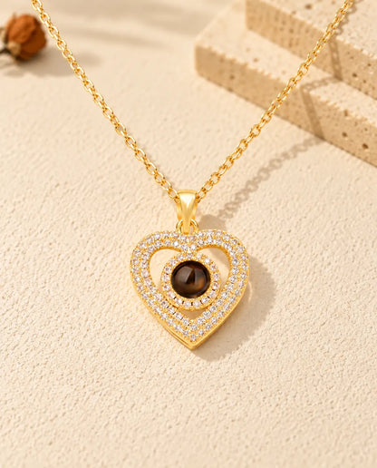 Front view of the gold tone double heart pave photo projection necklace