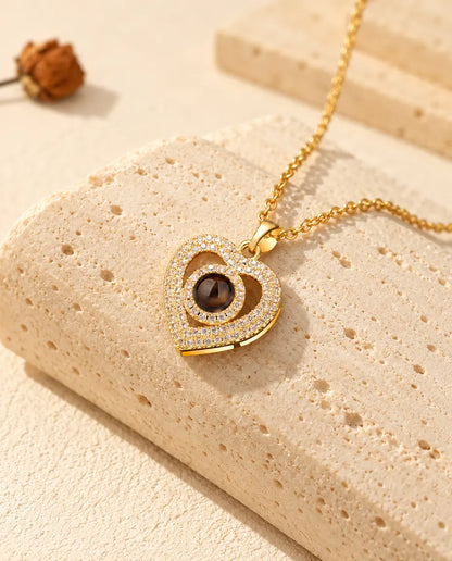 Gold tone double heart necklace with a projection stone at the center on travertine