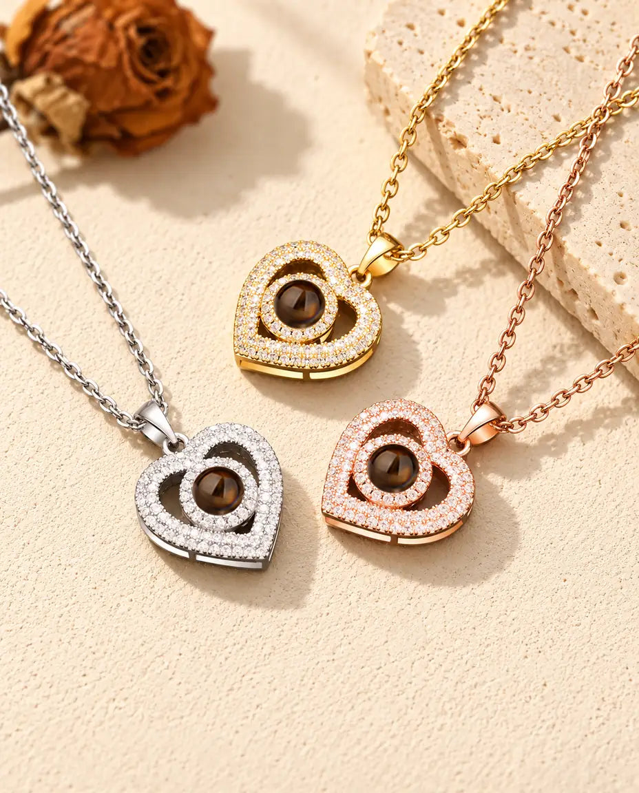 Gold tone, silver tone and rose gold tone double heart necklaces beside a travertine slab