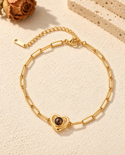 Top view of the gold tone double heart projection bracelet with its extender chain