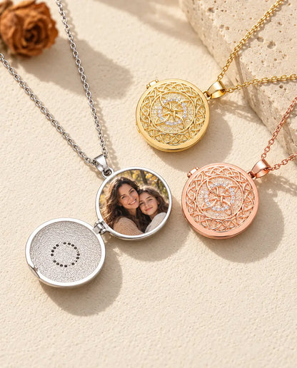 Silver tone four-loop Celtic knot photo locket opened to show a mother and daughter photo inside, beside closed gold tone and rose gold tone lockets