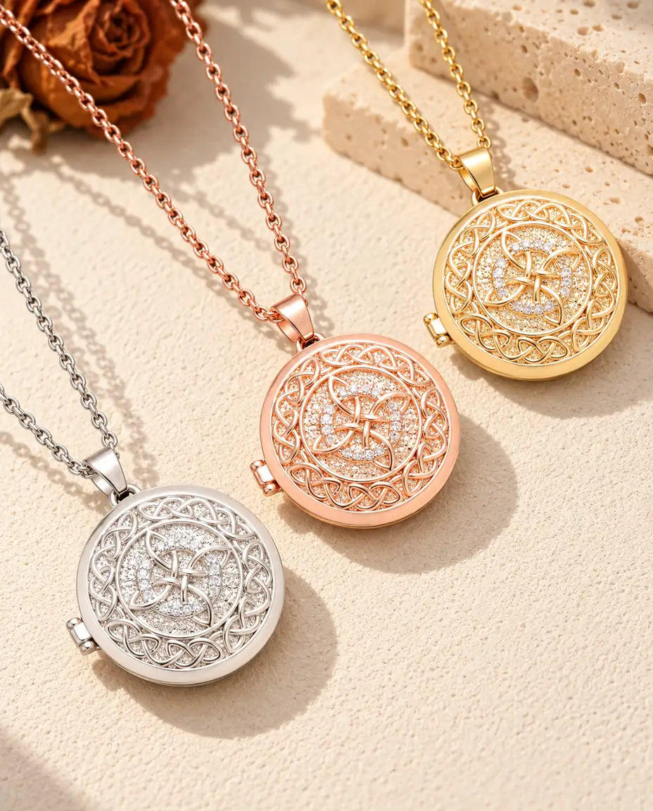 Four-loop Celtic knot photo lockets in silver tone, rose gold tone and gold tone laid diagonally on cream plaster