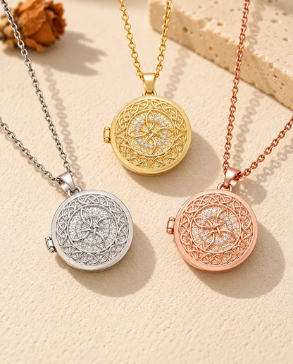 Three colors of the four-loop Celtic knot photo locket necklace arranged on plaster