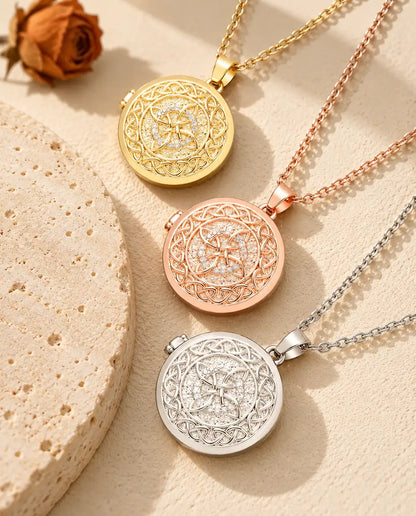 Gold tone, rose gold tone and silver tone four-loop Celtic knot photo lockets stacked beside a travertine slab