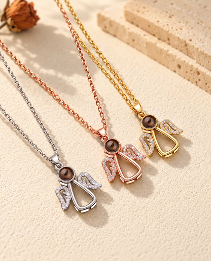 Silver tone, rose gold tone and gold tone angel necklaces on plaster