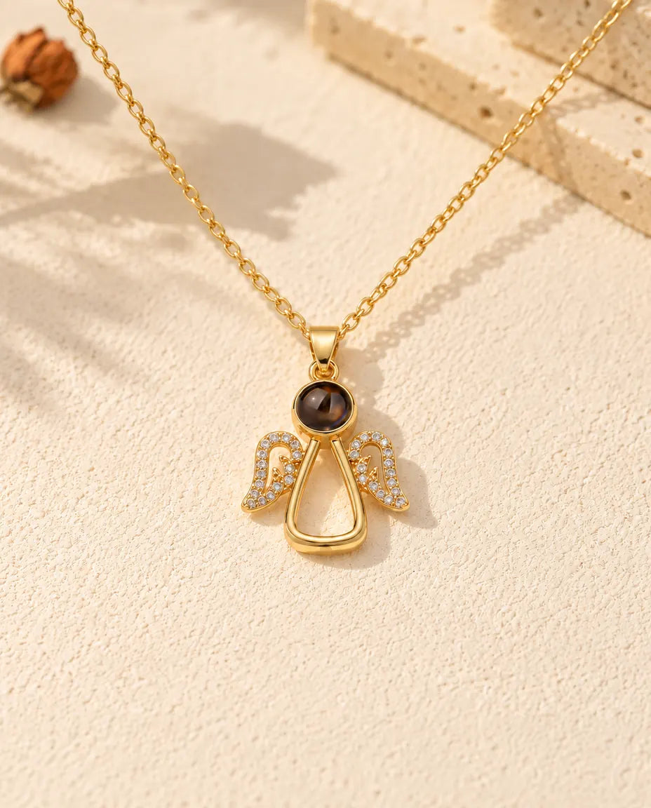 Front view of the gold tone angel pendant with the projection stone as its head