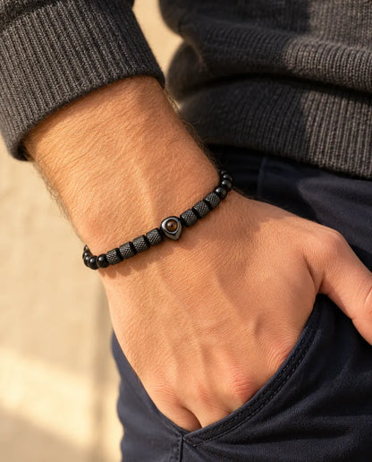 Man wearing the black heart photo projection bead bracelet, thumb hooked in his pocket
