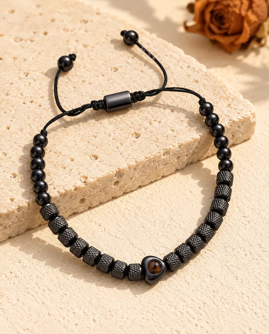 Black textured bead bracelet with a heart projection bead, slider and cord ends