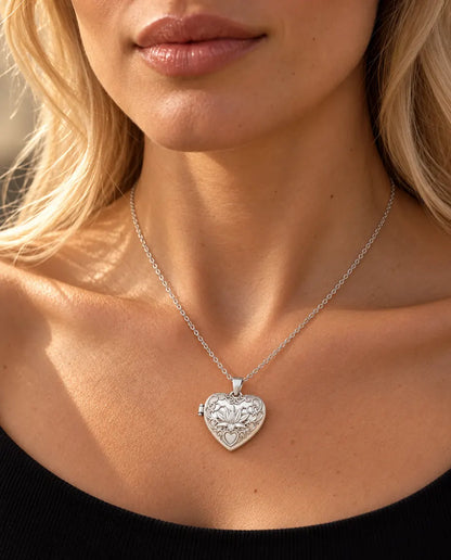 Woman in a black knit top wearing the silver tone lotus flower heart photo locket necklace
