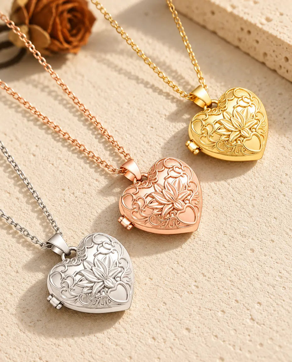 Lotus flower heart photo lockets in silver tone, rose gold tone and gold tone laid diagonally on cream plaster