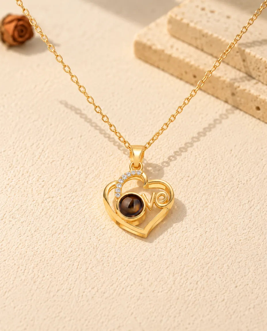 Front view of the gold tone Love heart projection pendant with the brown projection stone as the o