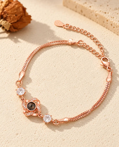 Rose gold tone love knot bracelet with sparkling side stones and a double box chain