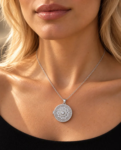 Woman in a black knit top wearing the silver tone mandala flower photo locket necklace