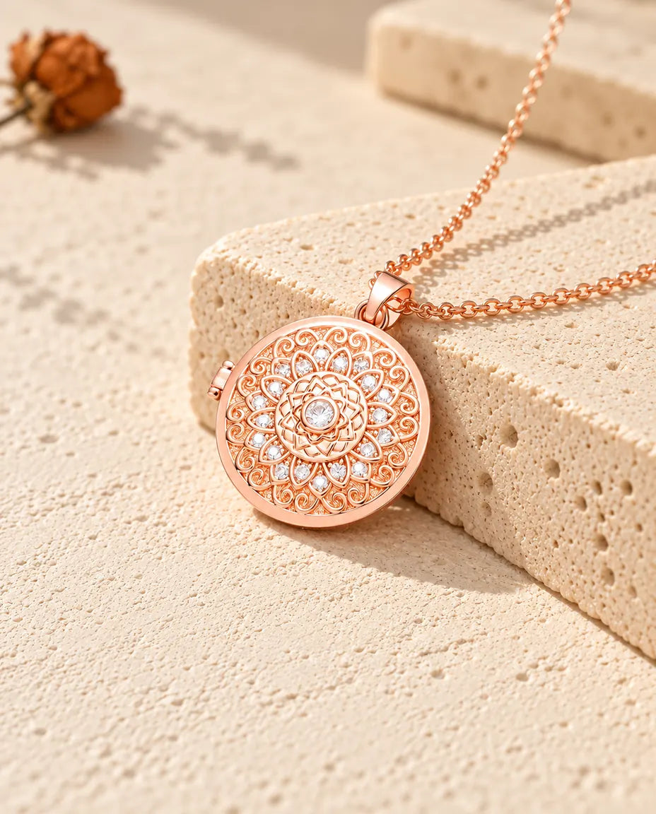 Rose gold tone mandala flower photo locket necklace on travertine in warm sunlight