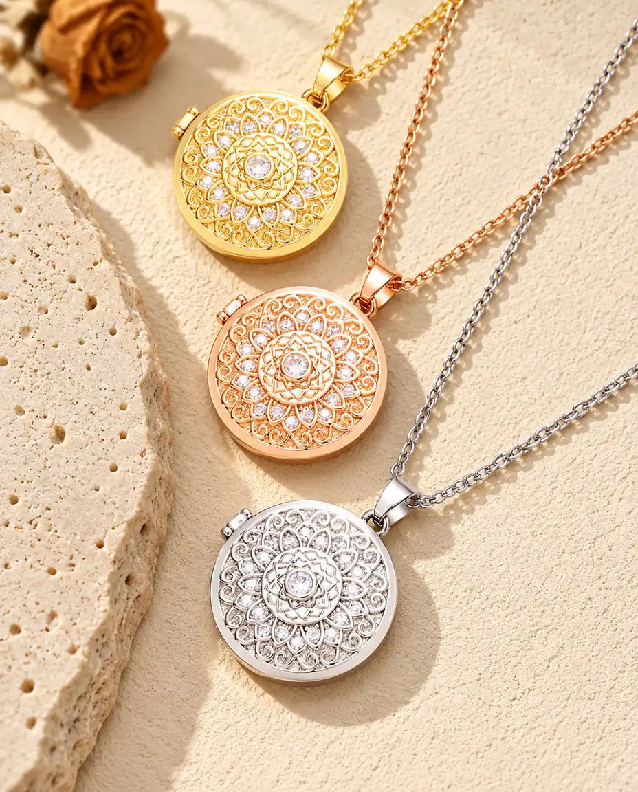 Gold tone, rose gold tone and silver tone mandala flower photo lockets stacked beside a travertine slab