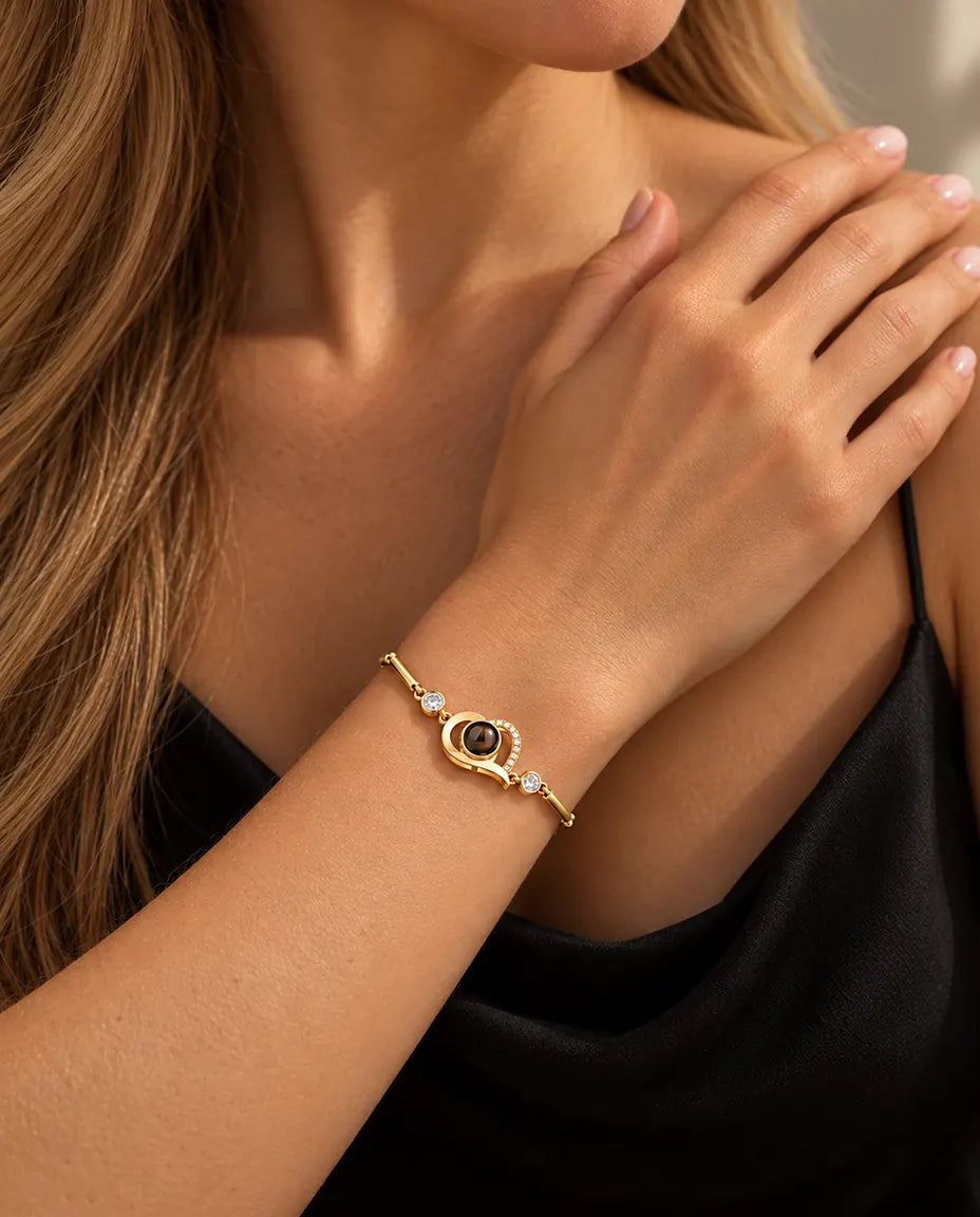 Close-up of the gold tone open heart bracelet with cubic zirconia on a wrist at the collarbone