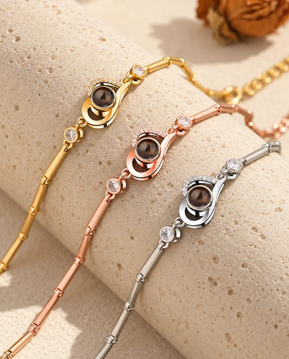 Three open heart projection bracelets in gold tone, rose gold tone and silver tone over a travertine block