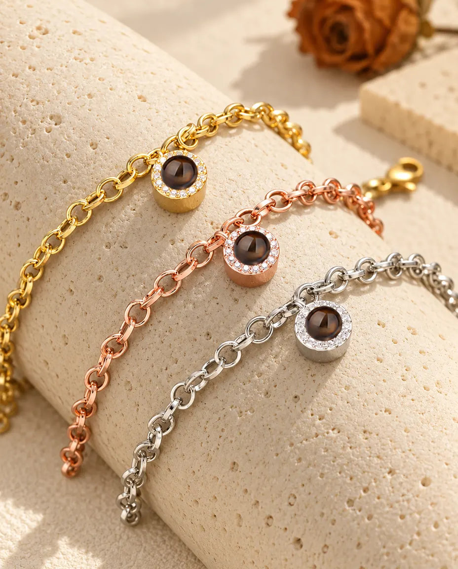 Gold tone, rose gold tone and silver tone pave circle projection bracelets draped over a travertine block