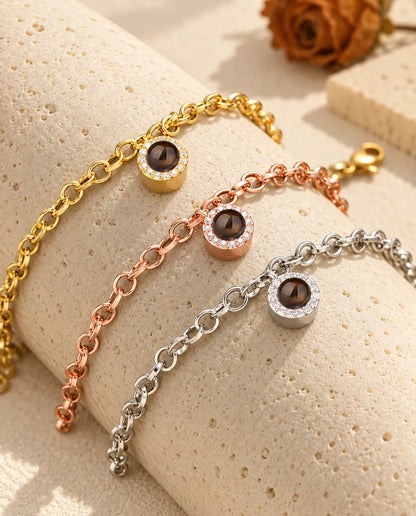 Gold tone, rose gold tone and silver tone pave circle projection bracelets draped over a travertine block