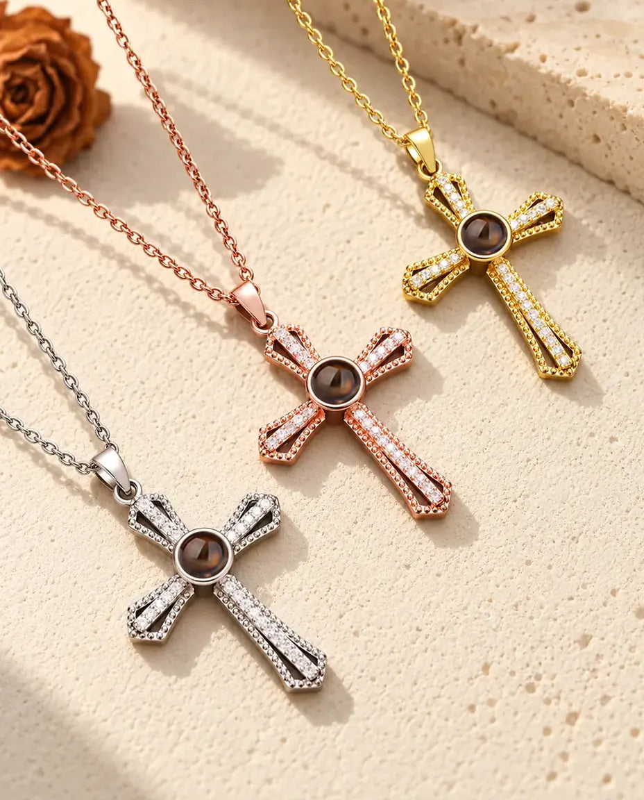 Pave cross projection necklaces in silver tone, rose gold tone and gold tone on a diagonal