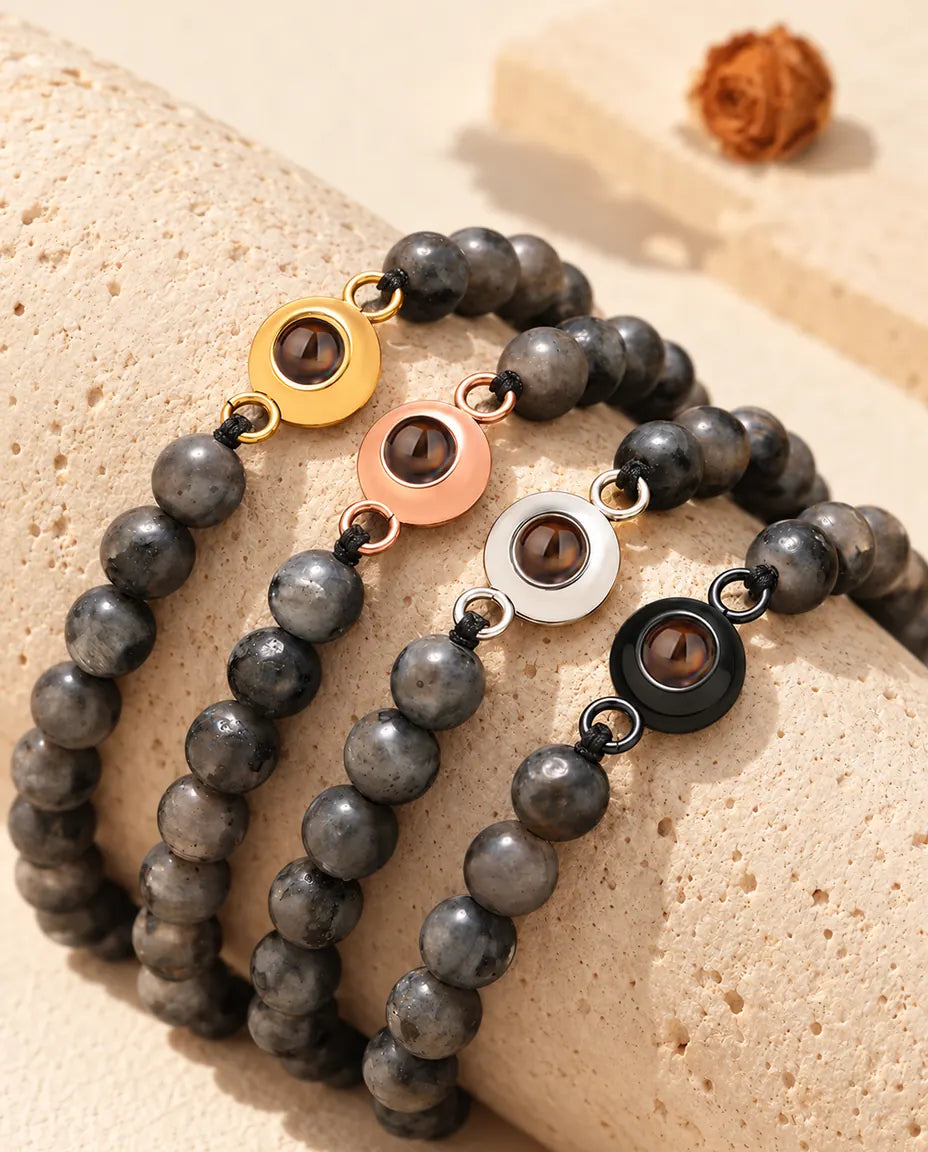 Gray speckled bead projection bracelets with gold tone, rose gold tone, silver tone and black charms