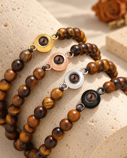 Tiger's eye bead projection bracelets in all four charm colors on a travertine block