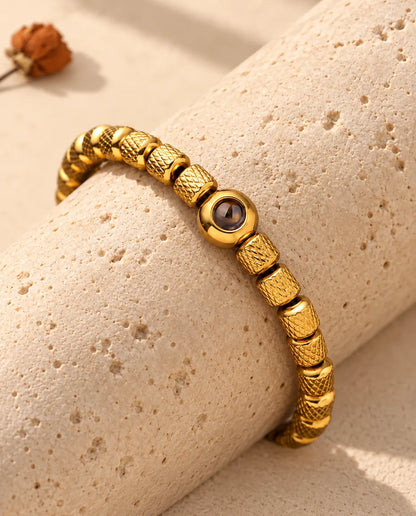 Close-up of the gold tone round projection bead between knurled barrel beads