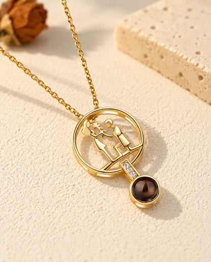 Front view of the gold tone circle pendant with a man kneeling to propose
