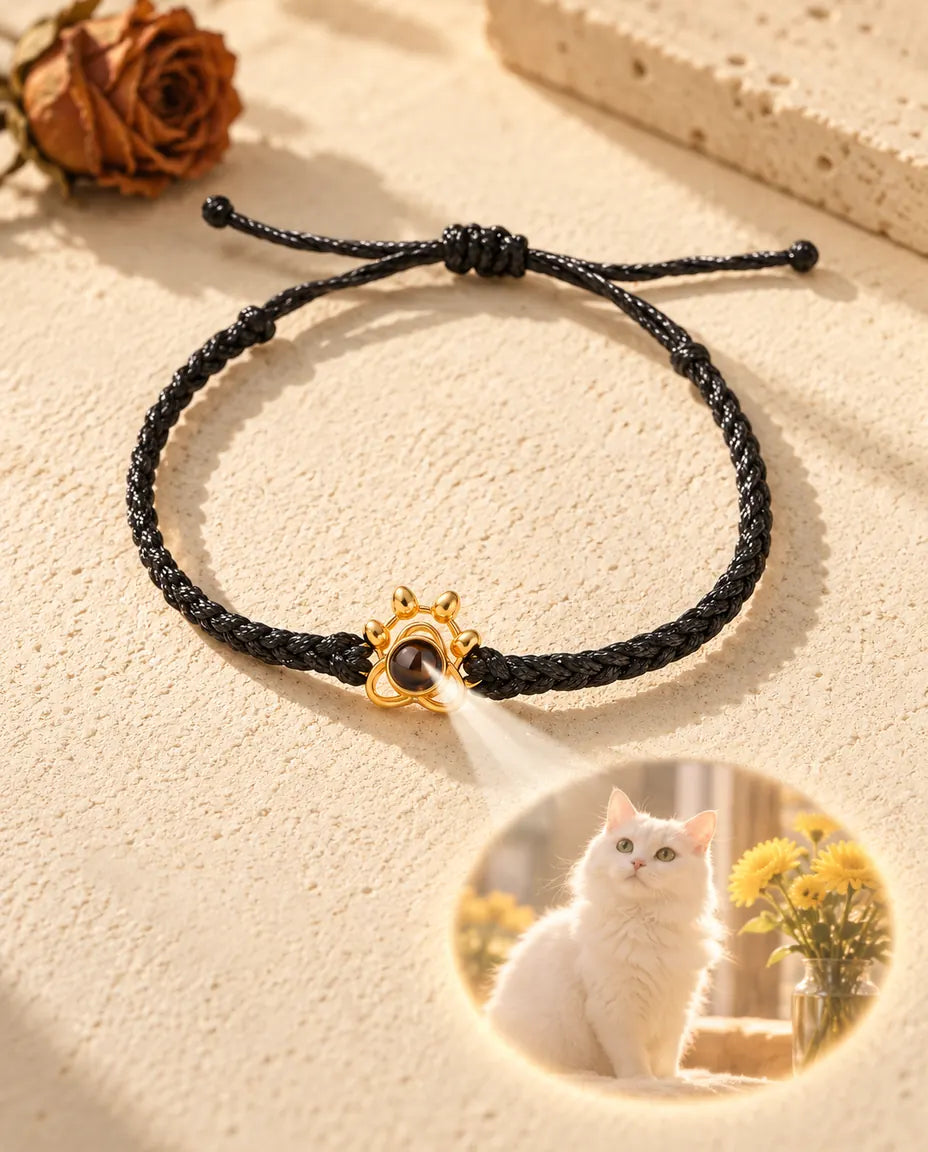 Light through the brown stone of the gold tone paw charm projects a round cat photo onto the plaster