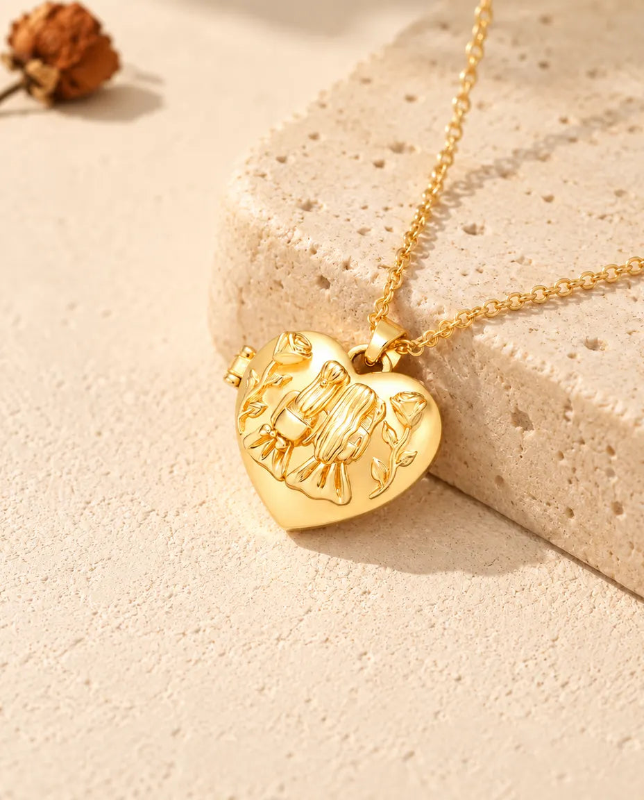 Gold tone sisters heart photo locket necklace resting on a travertine block
