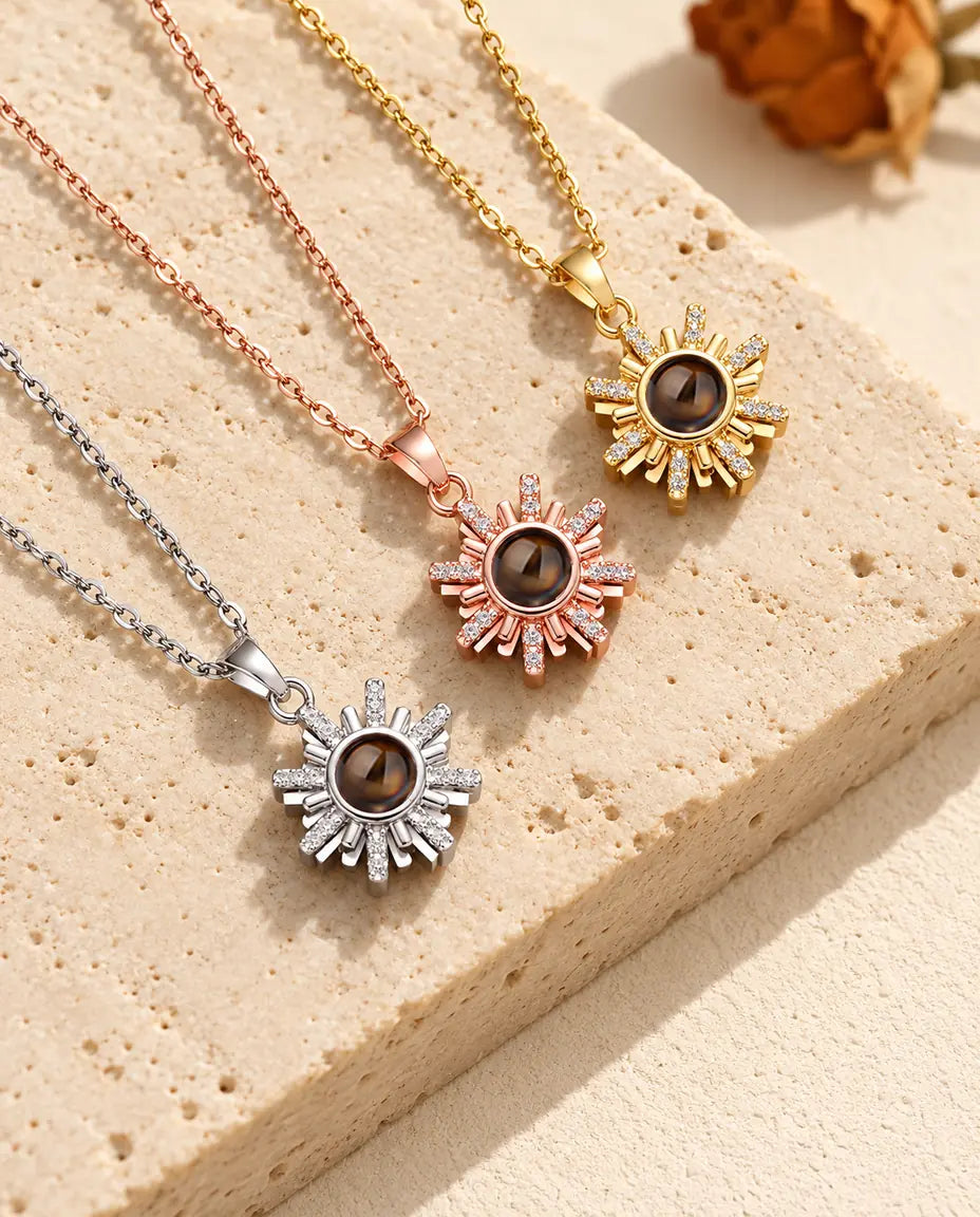 Three sunburst necklaces laid diagonally with cubic zirconia rays